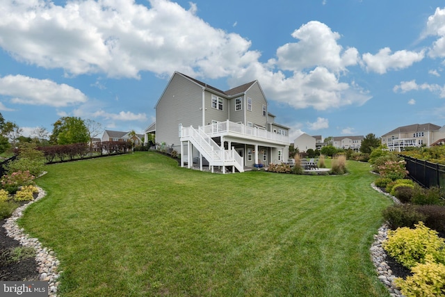 back of property with a yard and a deck