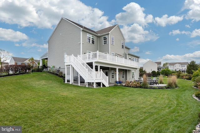 rear view of property featuring a patio, a deck, and a yard