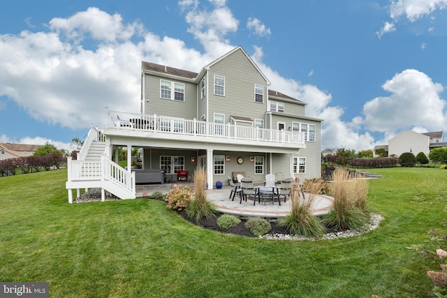 rear view of property with a yard, a wooden deck, and a patio area