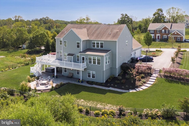 rear view of property with a lawn, a patio, and a balcony