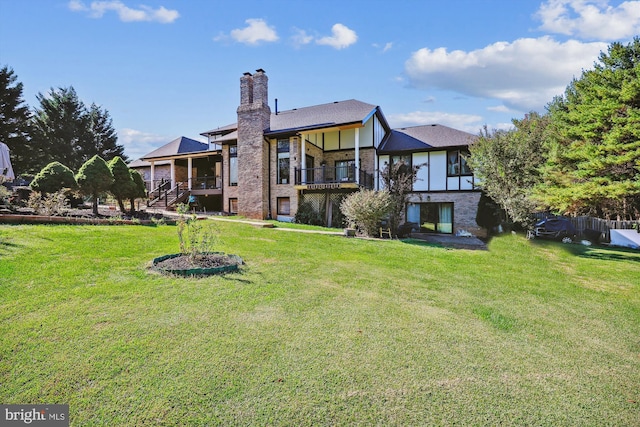 back of property with a lawn and a balcony