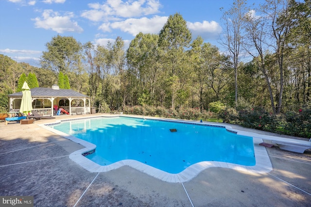 view of swimming pool with a patio area, a gazebo, and a diving board