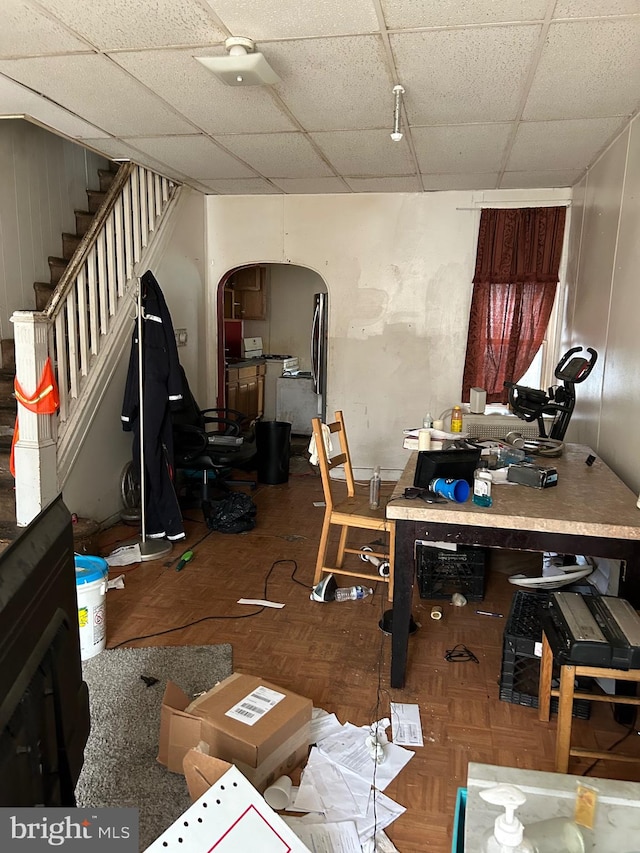 miscellaneous room with a drop ceiling and parquet flooring