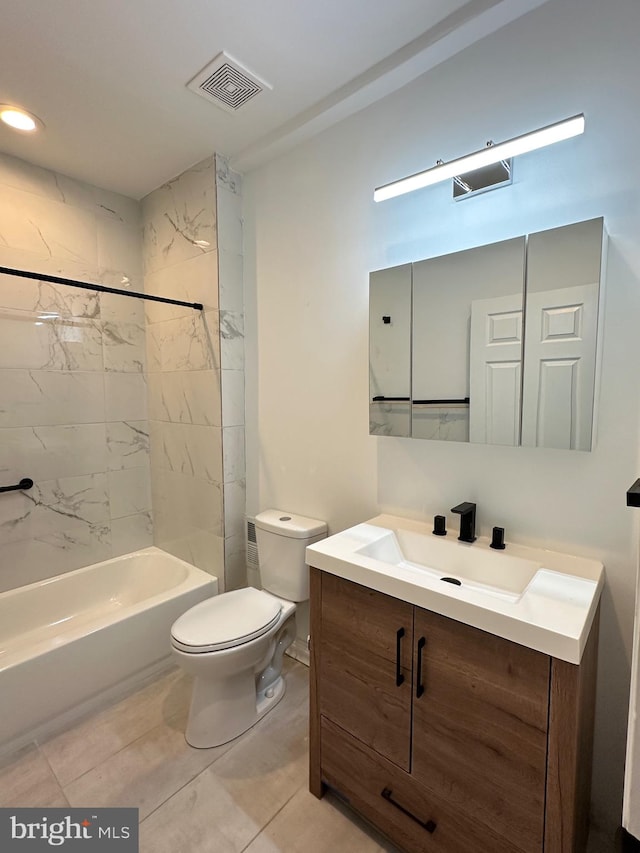 full bathroom featuring tile patterned flooring, tiled shower / bath, vanity, and toilet