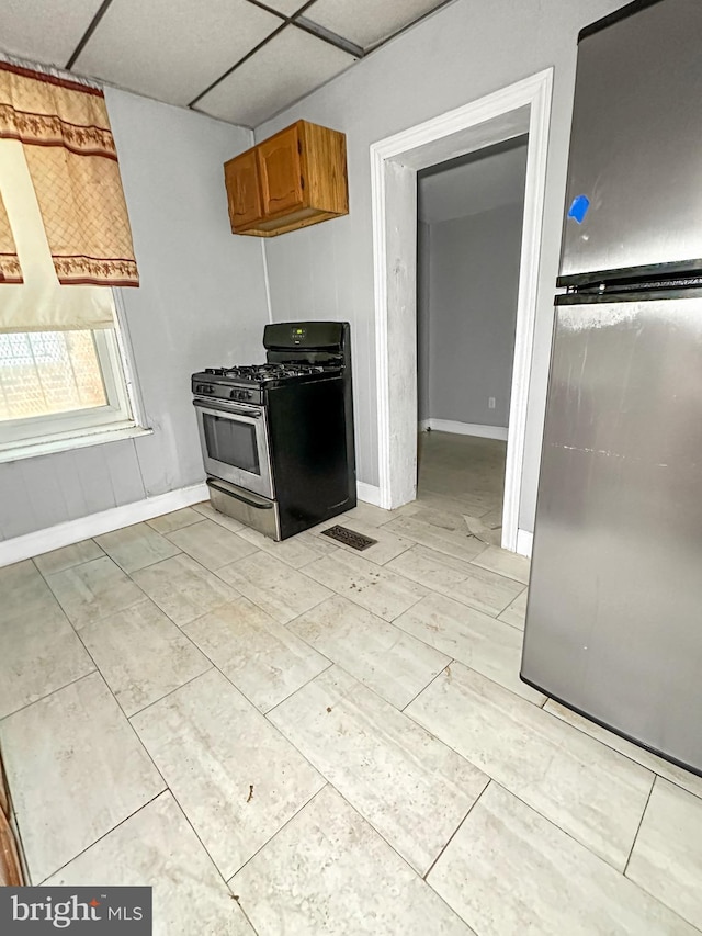 kitchen with a drop ceiling and stainless steel gas range