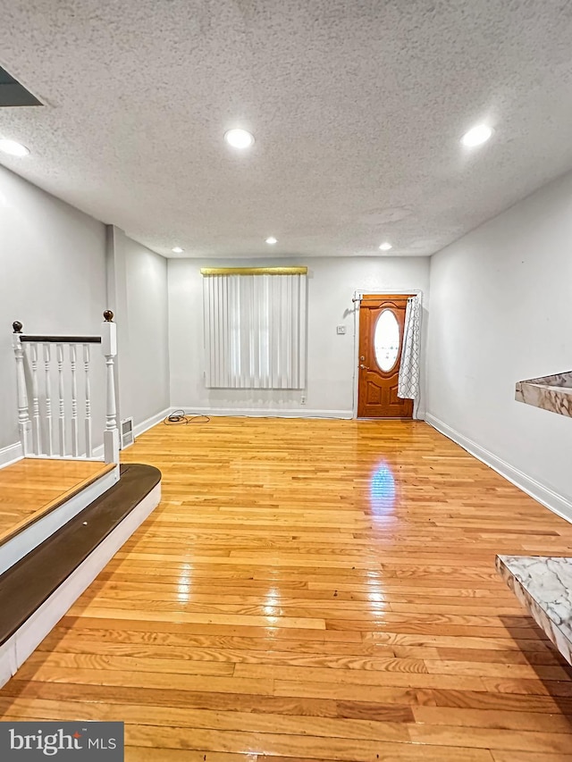 foyer featuring a textured ceiling and light wood-type flooring