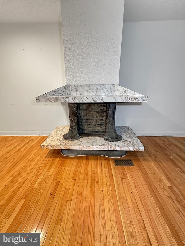 room details with a textured ceiling and hardwood / wood-style flooring