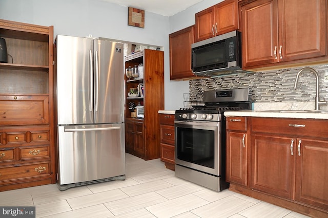 kitchen featuring appliances with stainless steel finishes, decorative backsplash, and sink