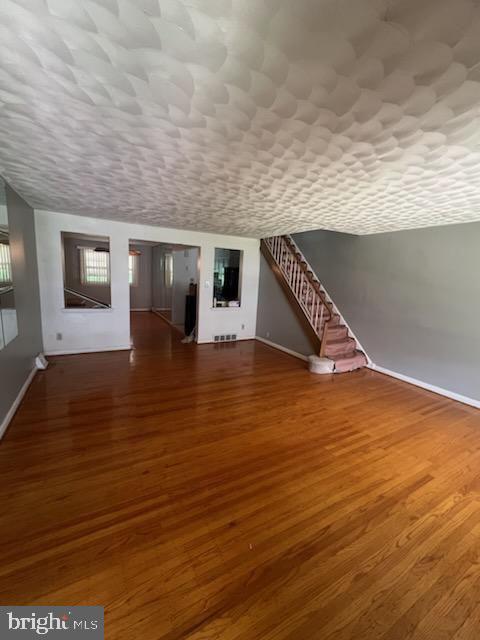 additional living space with dark wood-type flooring