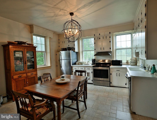 dining area featuring sink, plenty of natural light, a chandelier, and crown molding