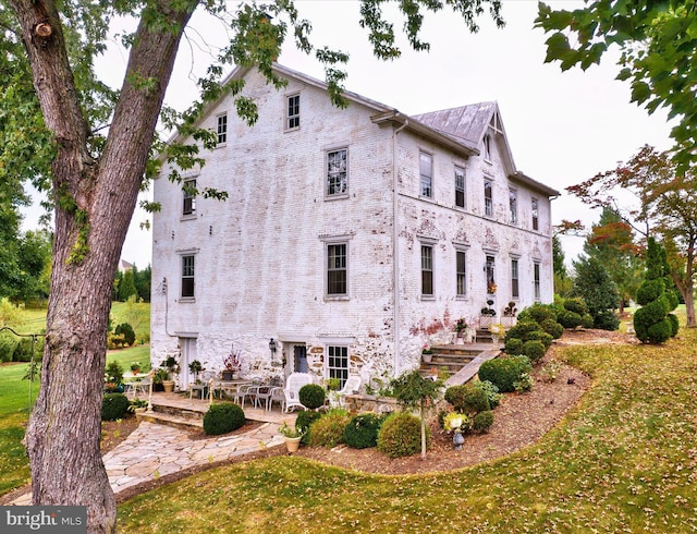 view of side of property featuring a lawn and a patio area