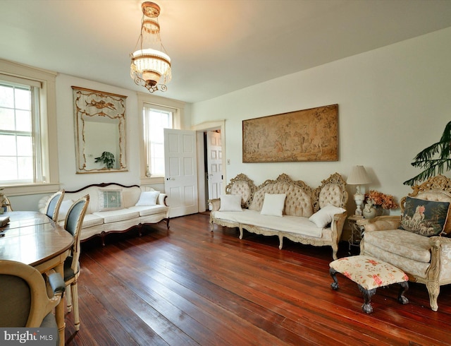 living room with a chandelier, plenty of natural light, and dark hardwood / wood-style flooring