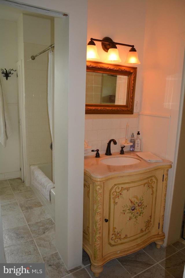 bathroom featuring vanity, shower / bathtub combination with curtain, and tasteful backsplash