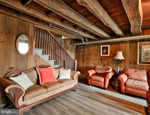 living room featuring beamed ceiling, light wood-type flooring, wood walls, and wood ceiling