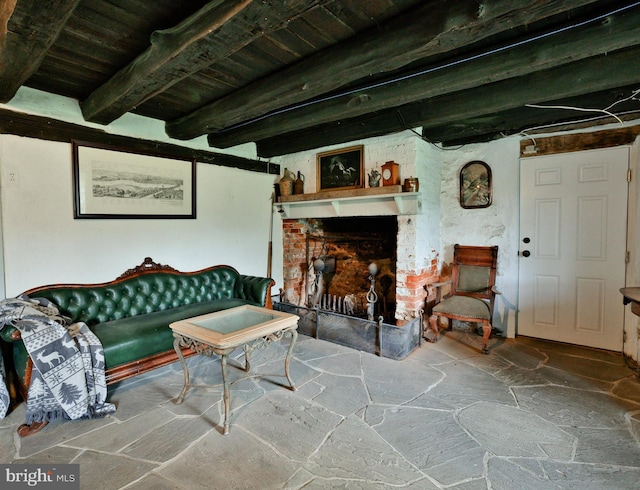 living room with a brick fireplace and beam ceiling