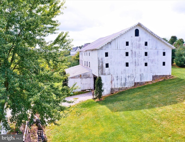 view of property exterior with a lawn and an outbuilding