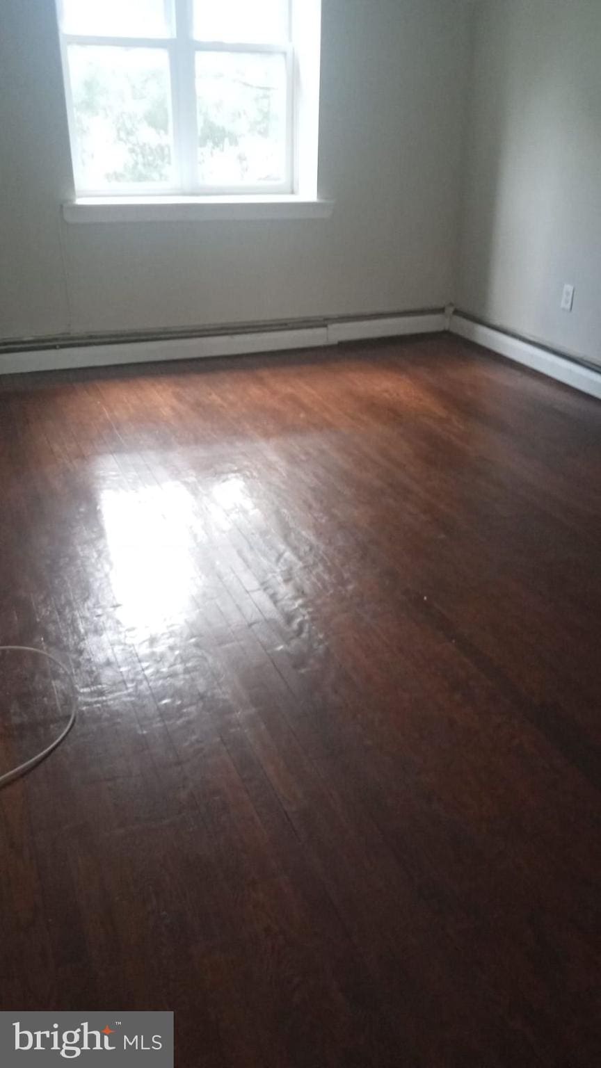 unfurnished room with dark wood-type flooring