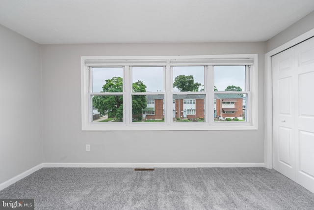 unfurnished bedroom featuring carpet flooring and multiple windows