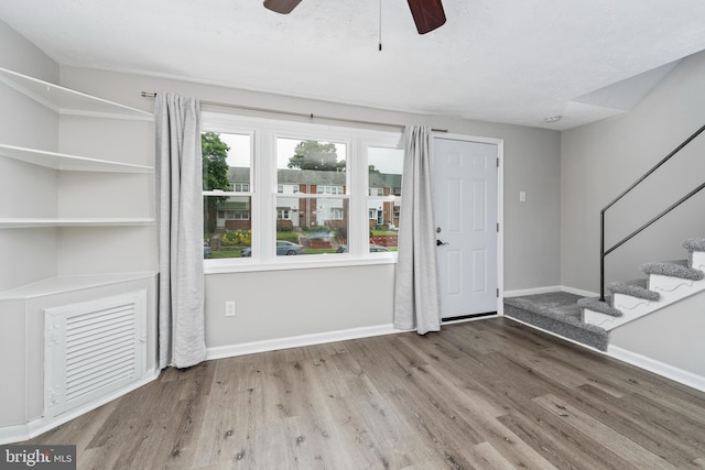 foyer featuring wood-type flooring, ceiling fan, and a textured ceiling