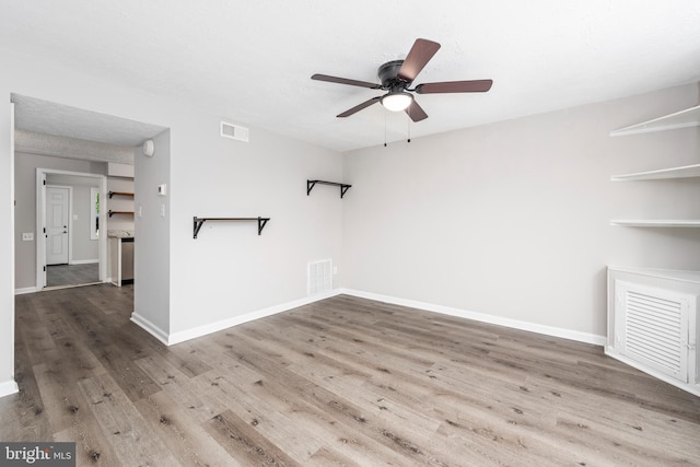 empty room with ceiling fan and hardwood / wood-style floors