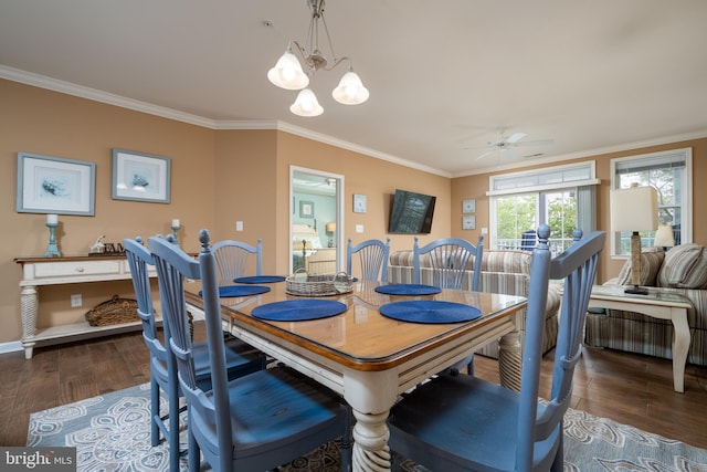 dining room featuring crown molding, ceiling fan with notable chandelier, and dark hardwood / wood-style flooring