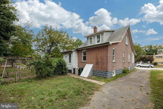 view of side of home with a lawn