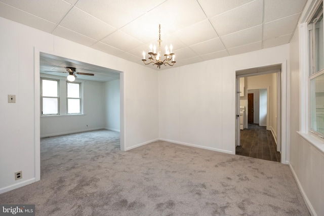 unfurnished room featuring ceiling fan with notable chandelier, carpet, and a paneled ceiling