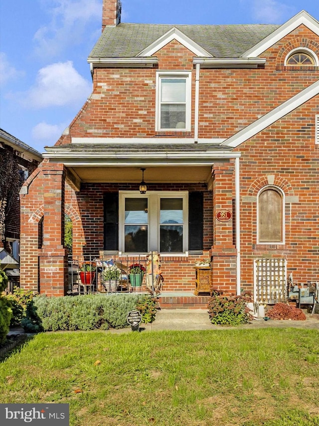 view of front of home with a front yard and a porch