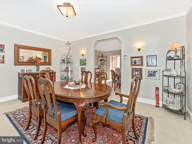 carpeted dining space with crown molding