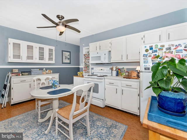 kitchen with white appliances, ceiling fan, light hardwood / wood-style flooring, and white cabinetry