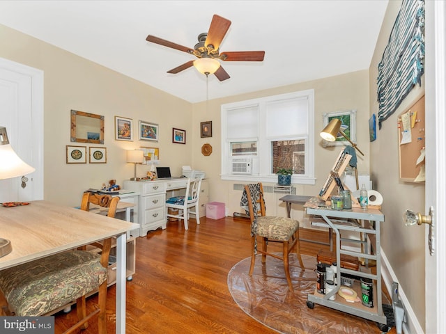 home office with ceiling fan, radiator, hardwood / wood-style floors, and built in desk