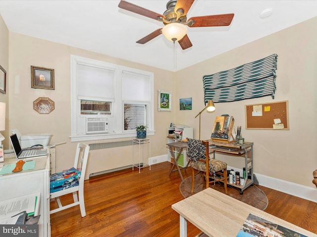 office space featuring ceiling fan, cooling unit, radiator heating unit, and wood-type flooring