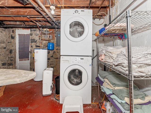 laundry area featuring gas water heater, stacked washer / drying machine, and electric panel