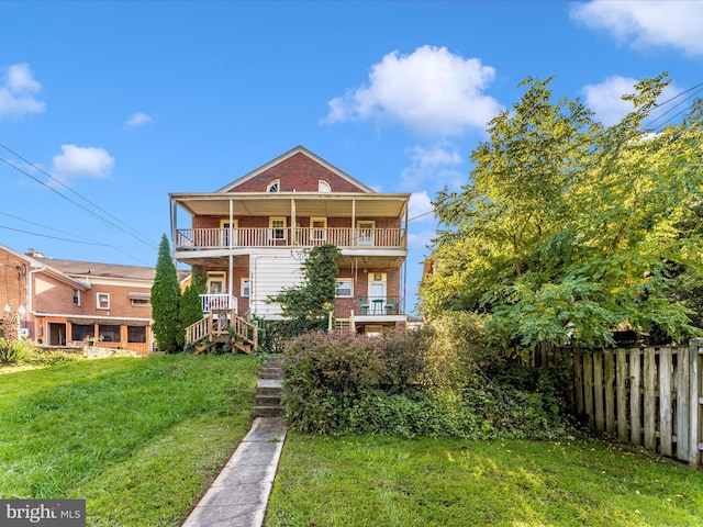 view of front of home with a balcony and a front lawn