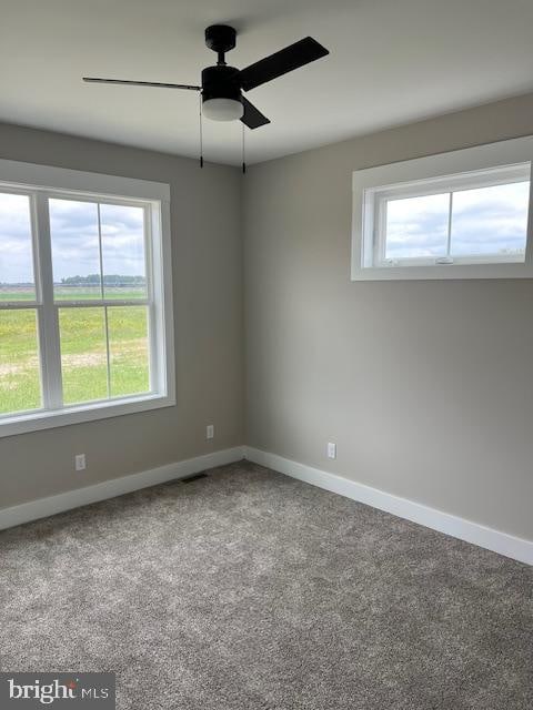 carpeted spare room featuring ceiling fan