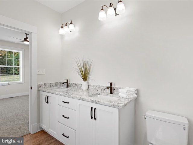 bathroom with vanity, toilet, hardwood / wood-style floors, and ceiling fan