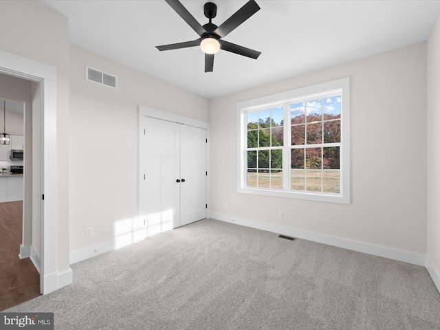 unfurnished bedroom with a closet, ceiling fan, and carpet