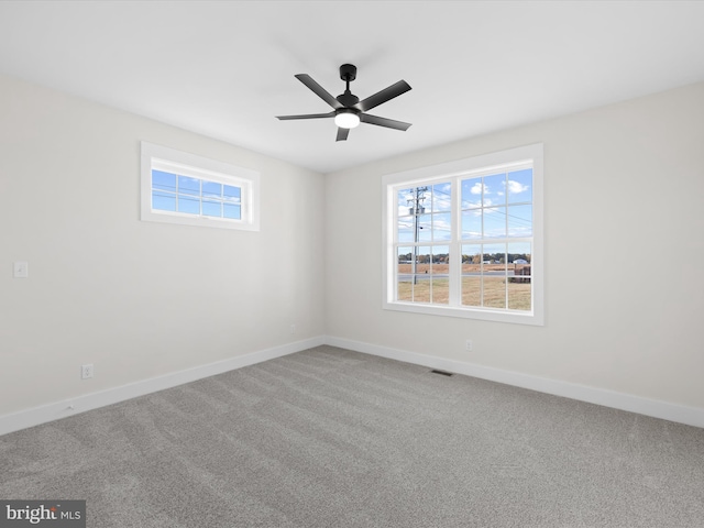 carpeted spare room featuring ceiling fan