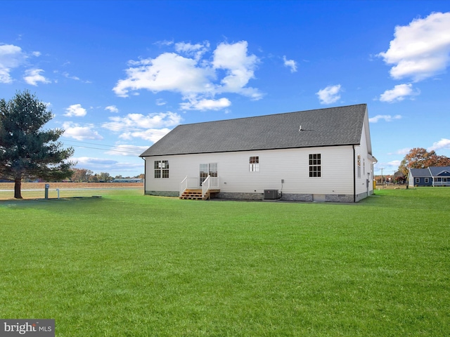 back of property featuring a yard and central air condition unit