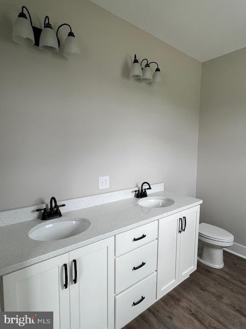 bathroom featuring vanity, toilet, and hardwood / wood-style flooring