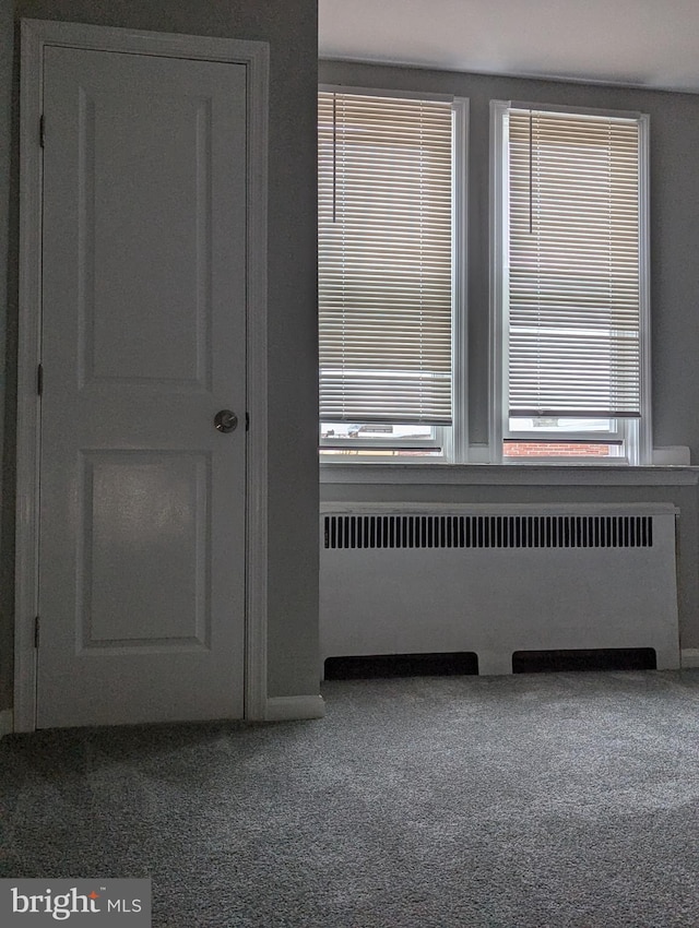 carpeted spare room featuring radiator