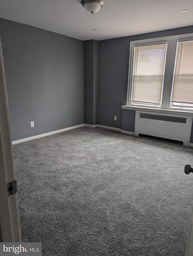 spare room with carpet and radiator heating unit