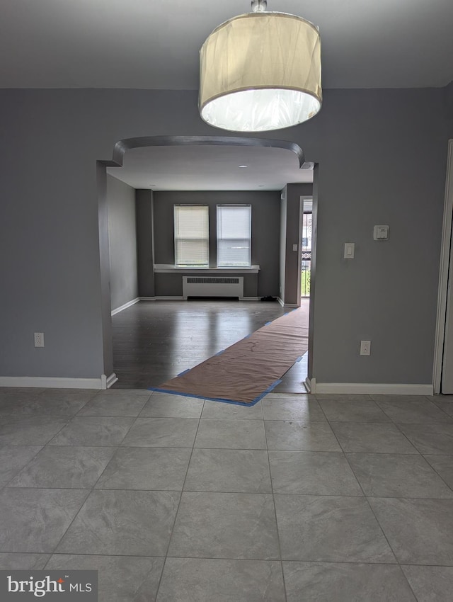 unfurnished room featuring radiator and hardwood / wood-style flooring