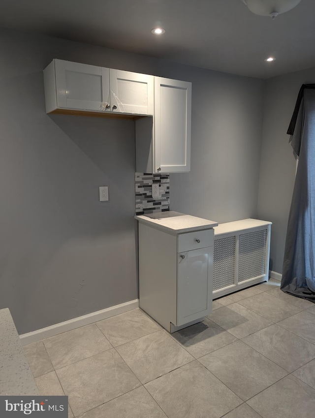 kitchen featuring decorative backsplash, white cabinetry, and light tile patterned floors