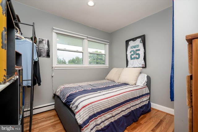 bedroom with baseboards, wood finished floors, baseboard heating, and recessed lighting