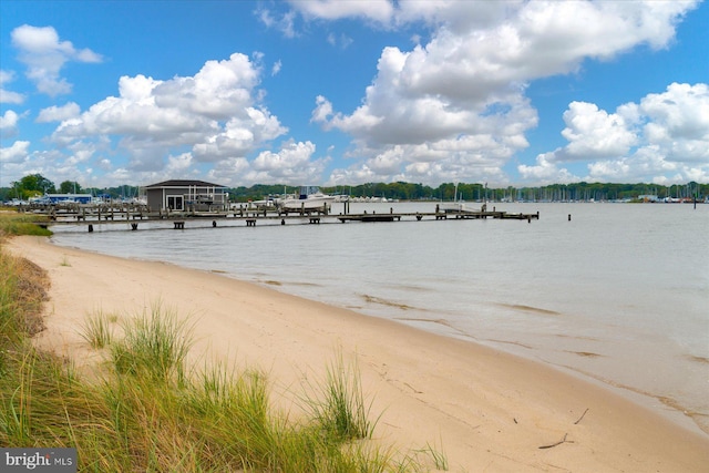 property view of water featuring a view of the beach and a boat dock