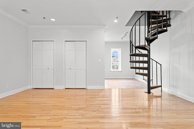 foyer with ornamental molding and light hardwood / wood-style flooring