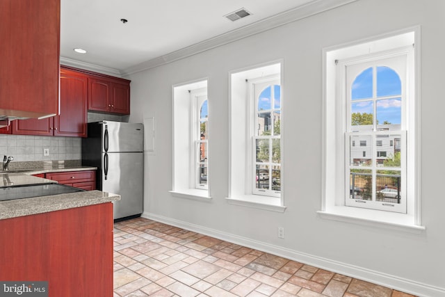 kitchen featuring sink, crown molding, tasteful backsplash, and stainless steel fridge