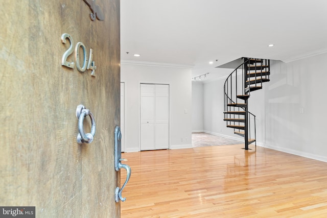 entryway featuring ornamental molding and hardwood / wood-style floors