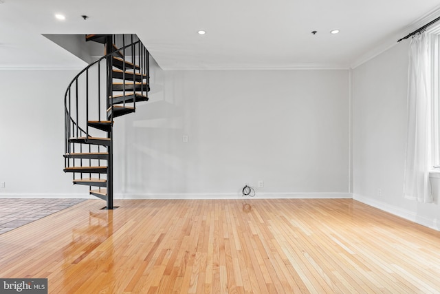 staircase with wood-type flooring and crown molding